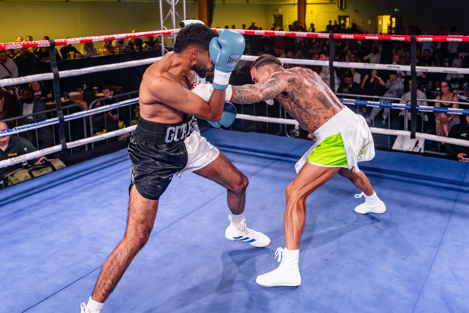A boxer throws a powerful uppercut punch during a professional boxing match in a ring.