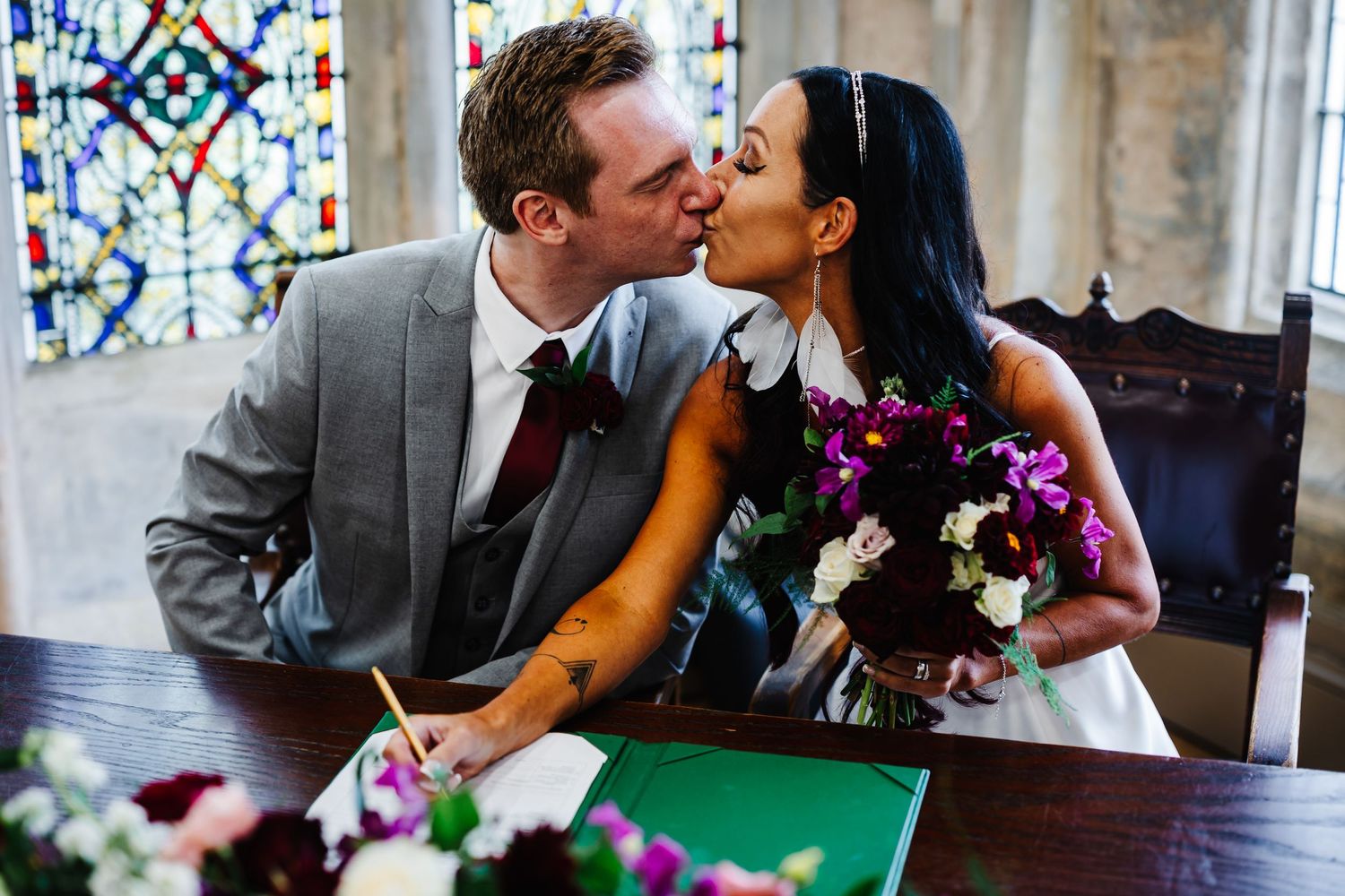 Romantic moment in a church with stained glass windows visible in the background.