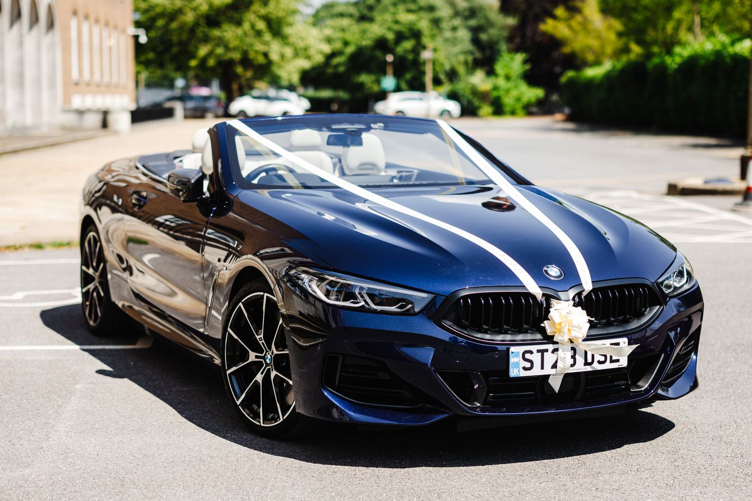 A sleek blue BMW sports car parked outdoors for wedding photography.