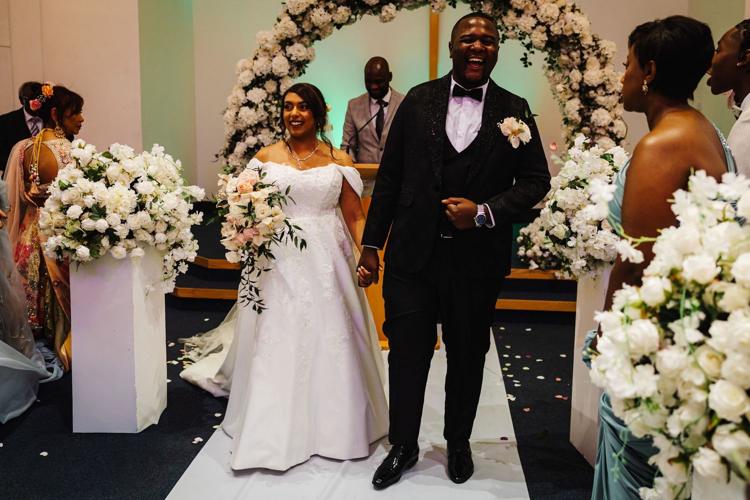 Wedding ceremony setup with elegant white floral arch and romantic decor.