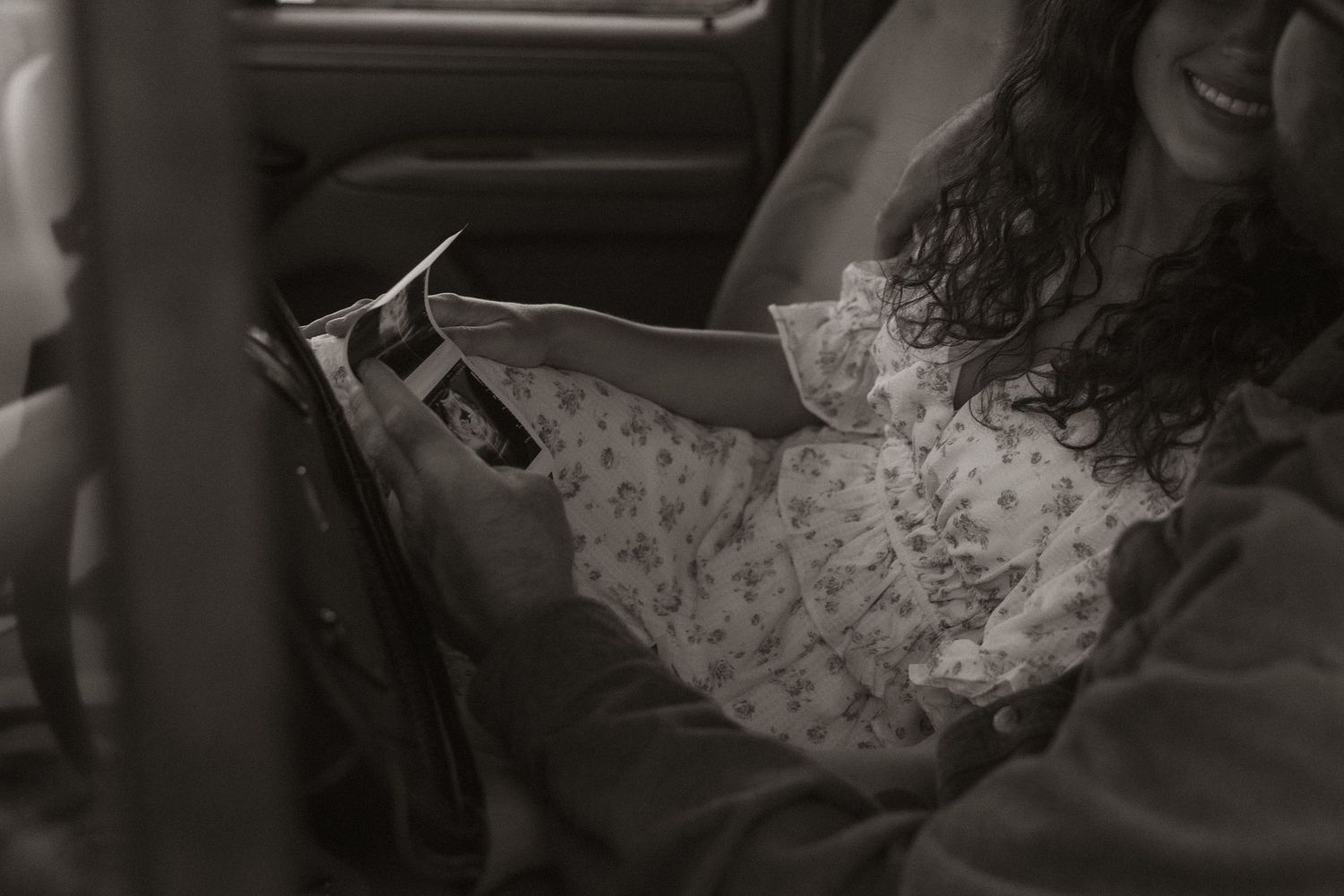 A soft, intimate black and white photograph capturing a quiet moment indoors.