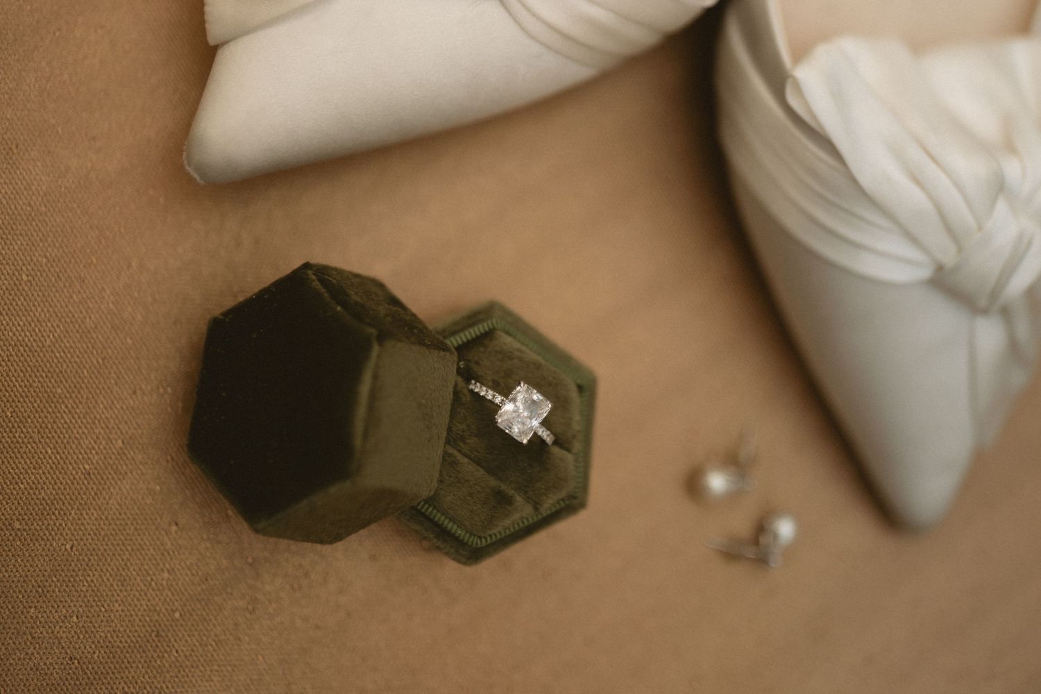Wedding detail shots featuring white shoes and engagement ring on beige background.