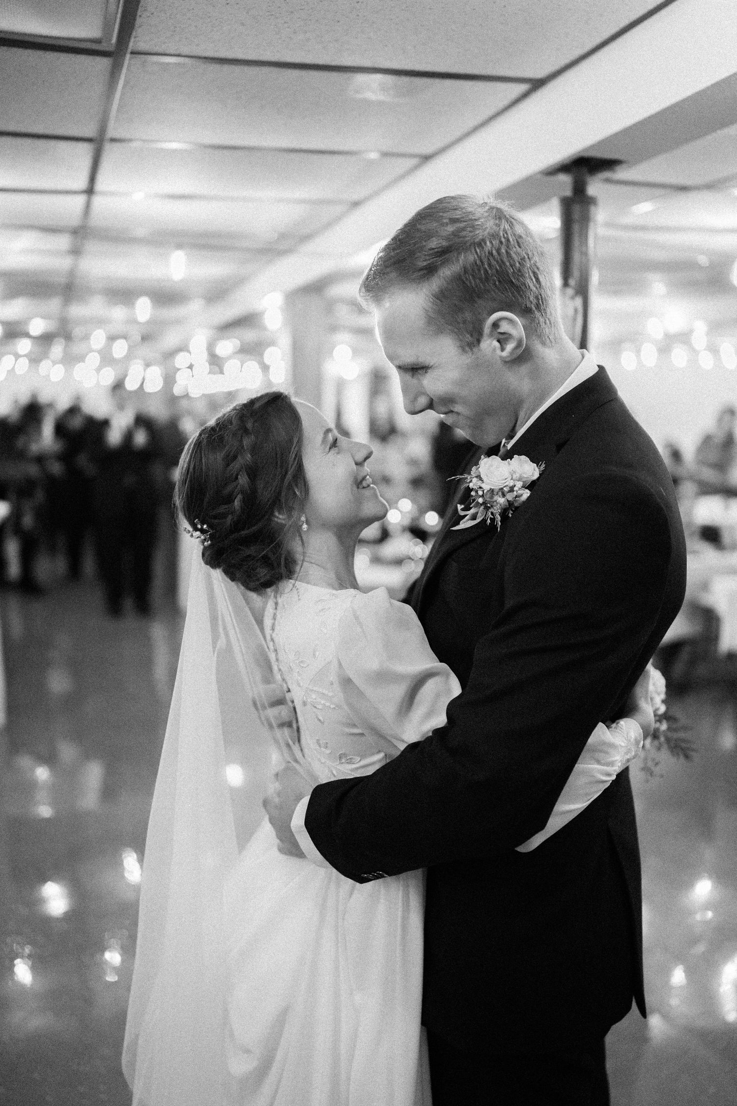 A romantic first dance sequence between newlyweds at their wedding reception shown in black and white photos.