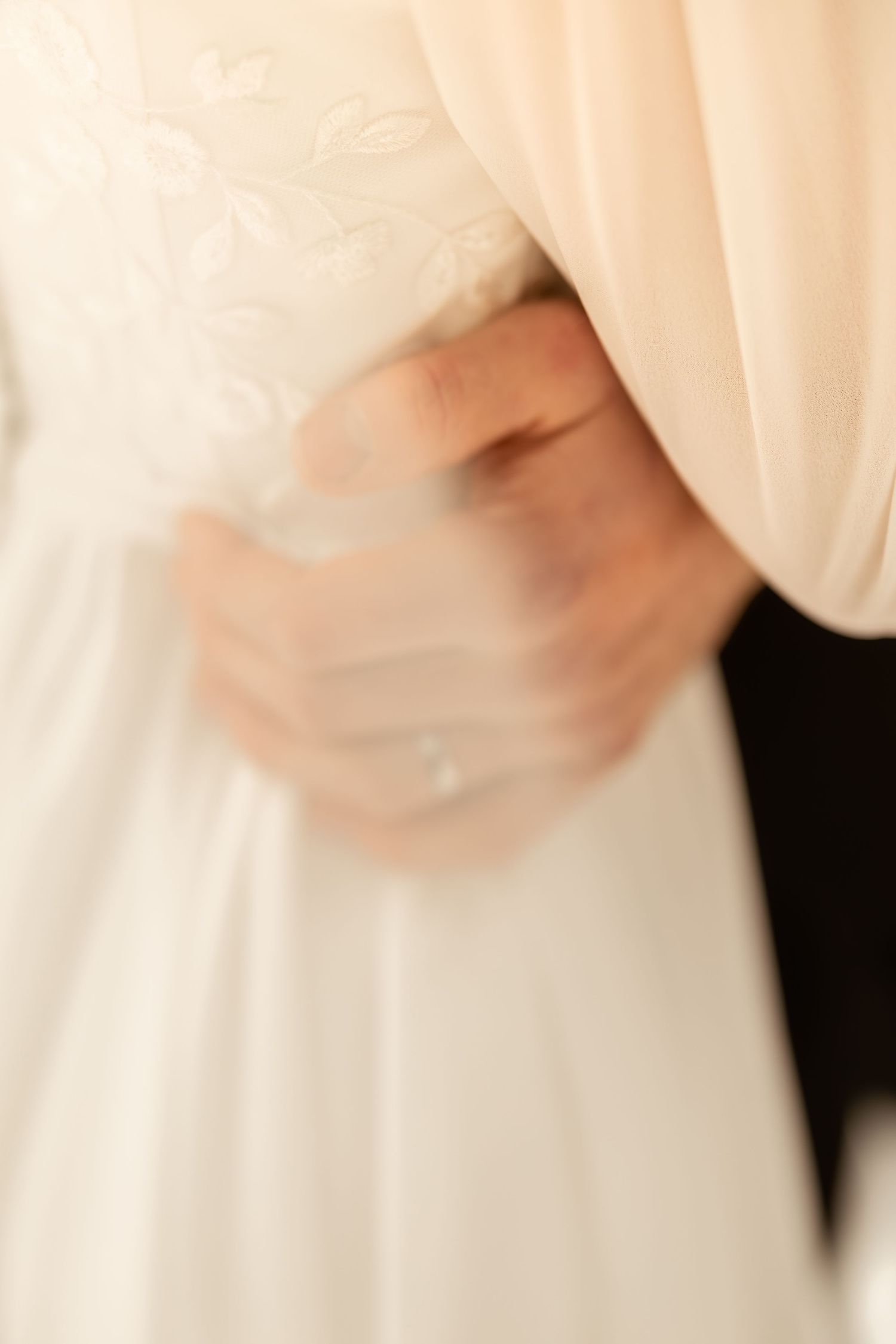 A close-up view of delicate ivory fabric with soft folds and gentle draping details.