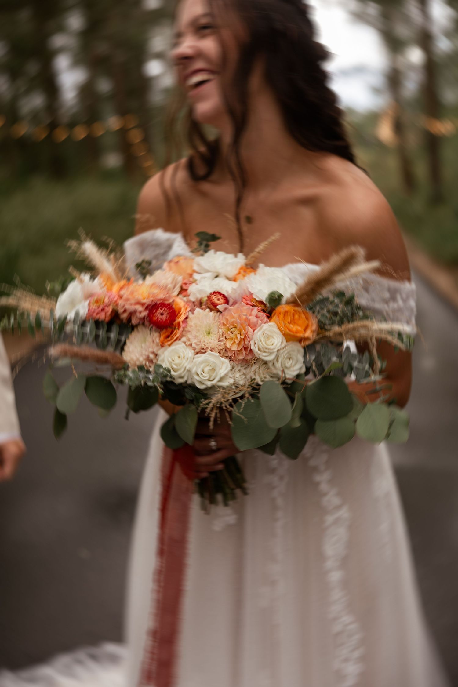 Beautiful bridal bouquet featuring orange and white roses with eucalyptus greenery.