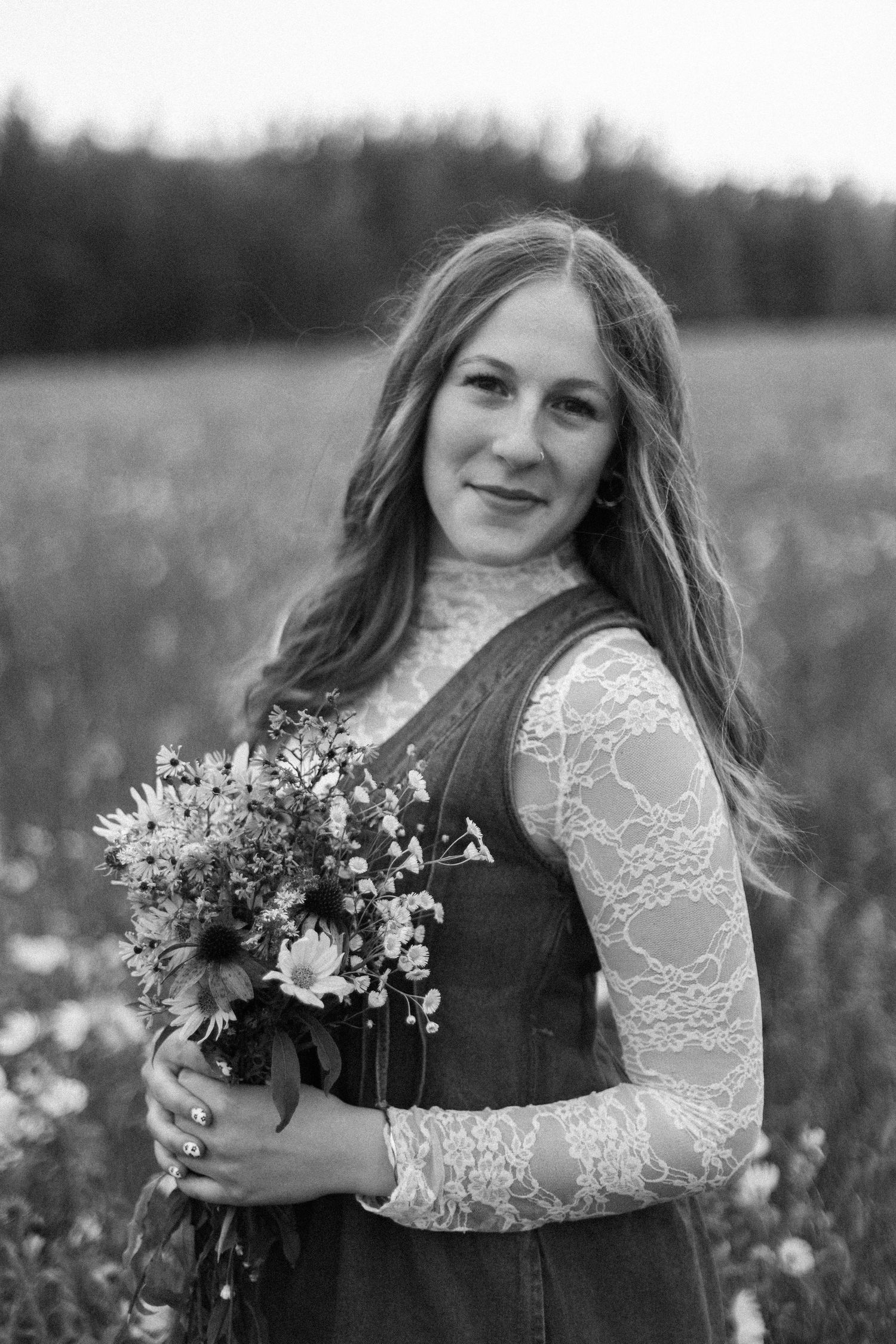 Black and white portrait session in a wildflower field with a lace dress and natural bouquet.