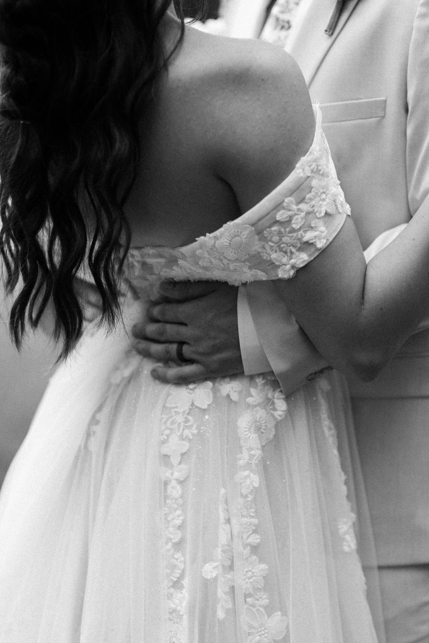Delicate lace details and embellishments adorn a white wedding dress bodice.