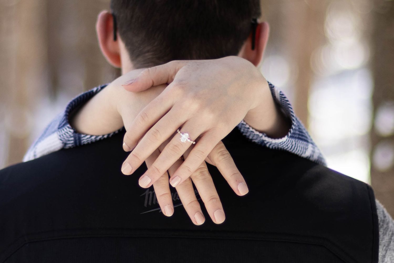 A close-up shot showing a hand with an engagement ring.