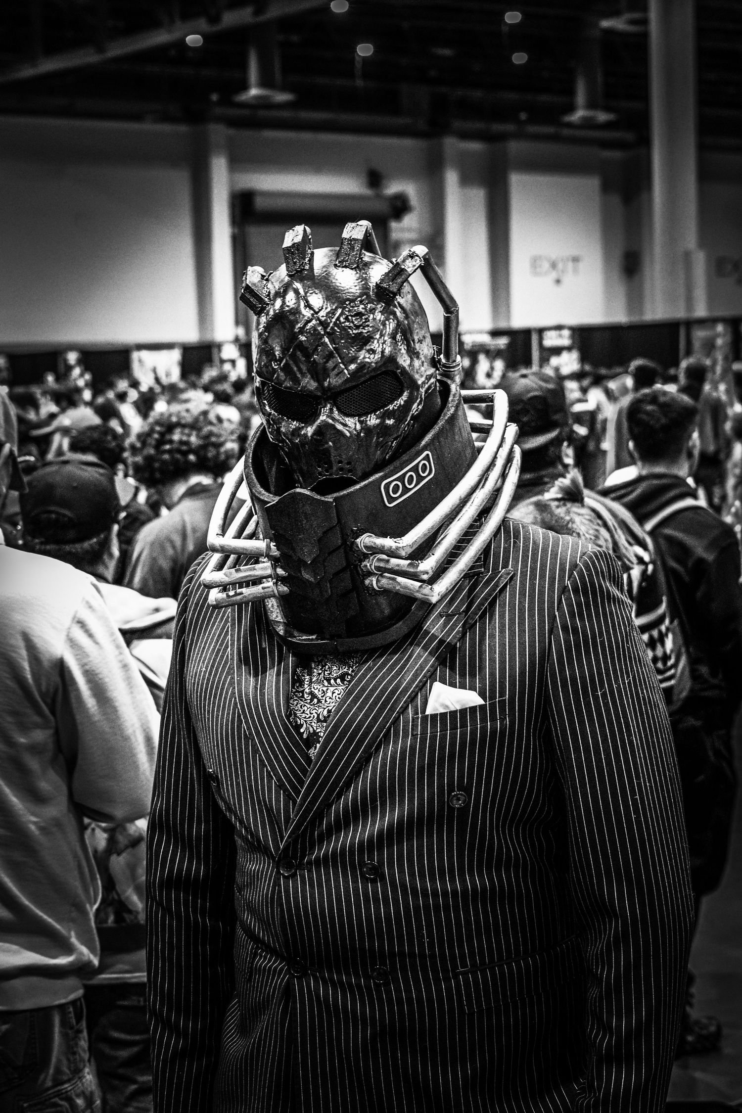 Black and white image of pinstriped formal suits on display at an event.