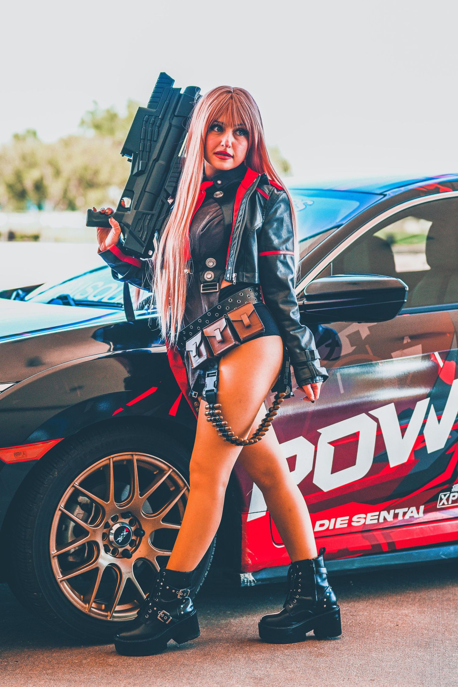 Cosplay photography featuring a sports car with custom decals and performance modifications.