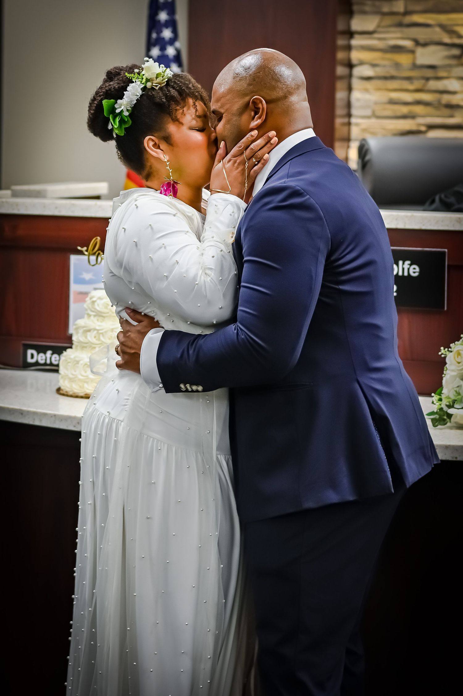 Wedding couple sharing their first kiss at the altar in formal attire.