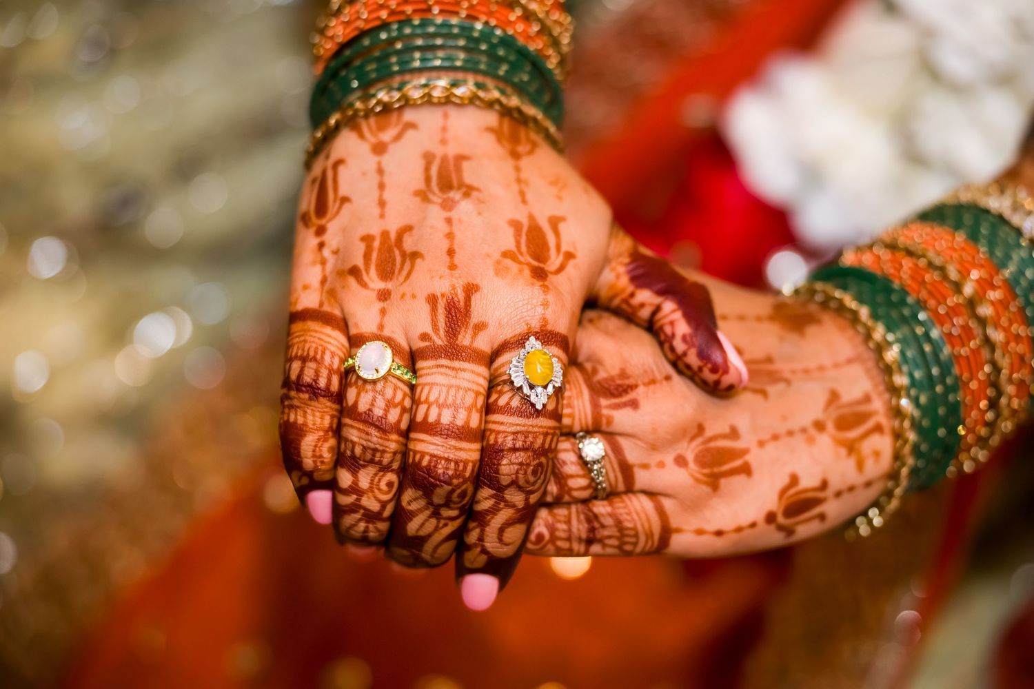 Close-up detail of traditional henna designs on hands during a wedding ceremony.