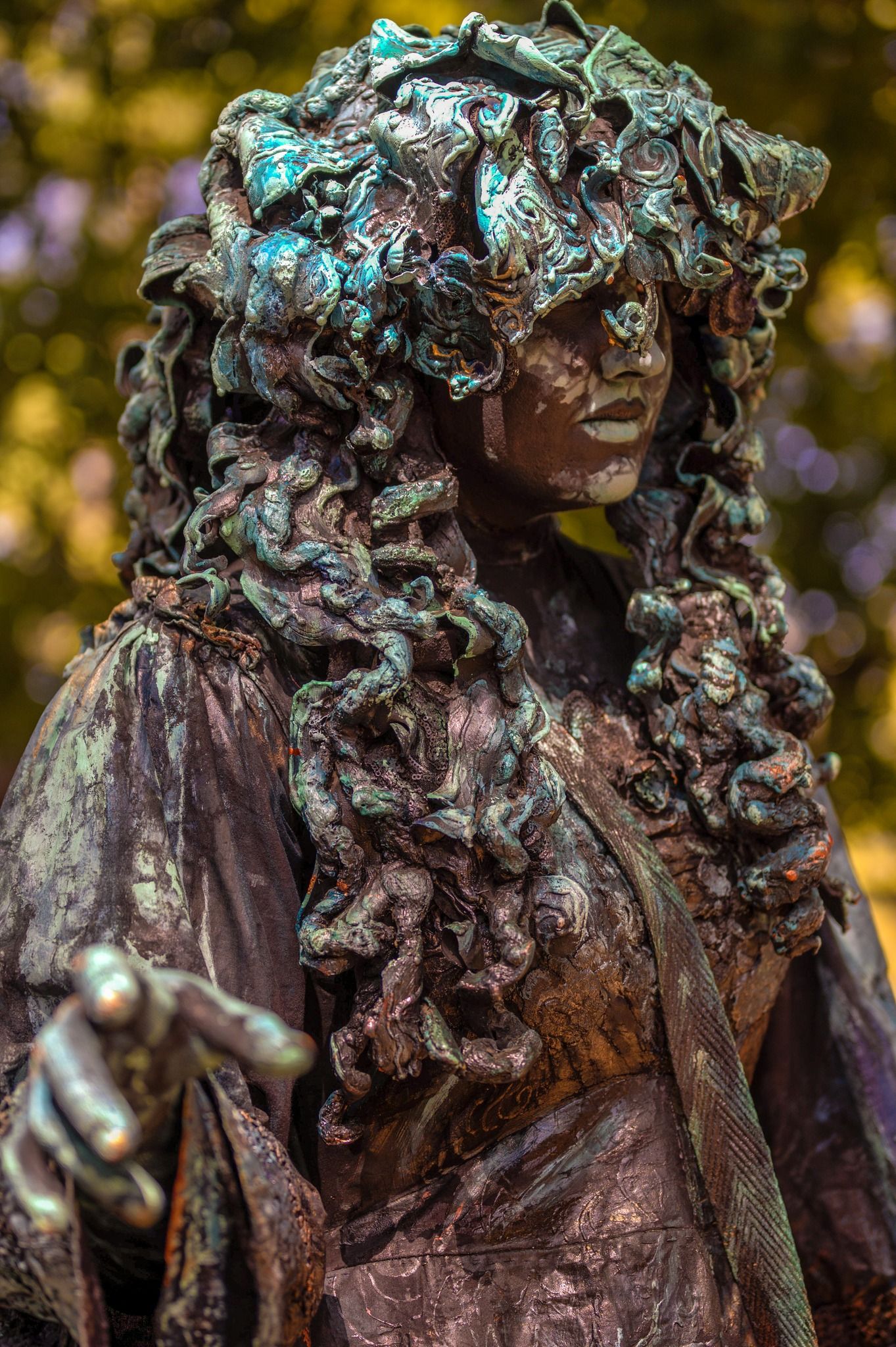 Bronze statue with intricate patinated details and flowing curls.