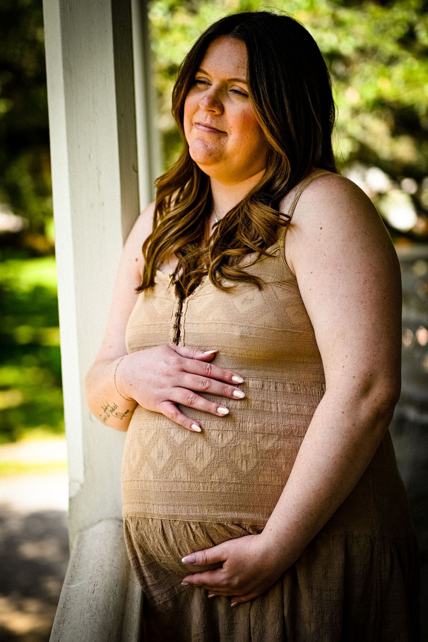 Natural light portraits featuring soft brown dress against textured background.