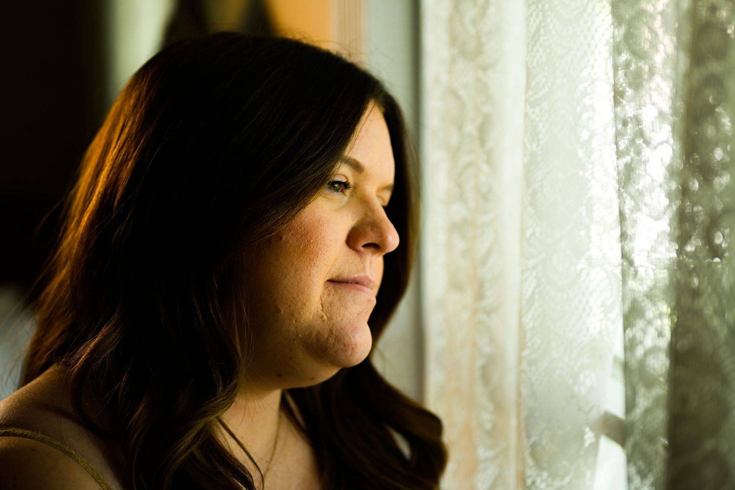 Silhouetted profile portraits against bright window with sheer curtains.