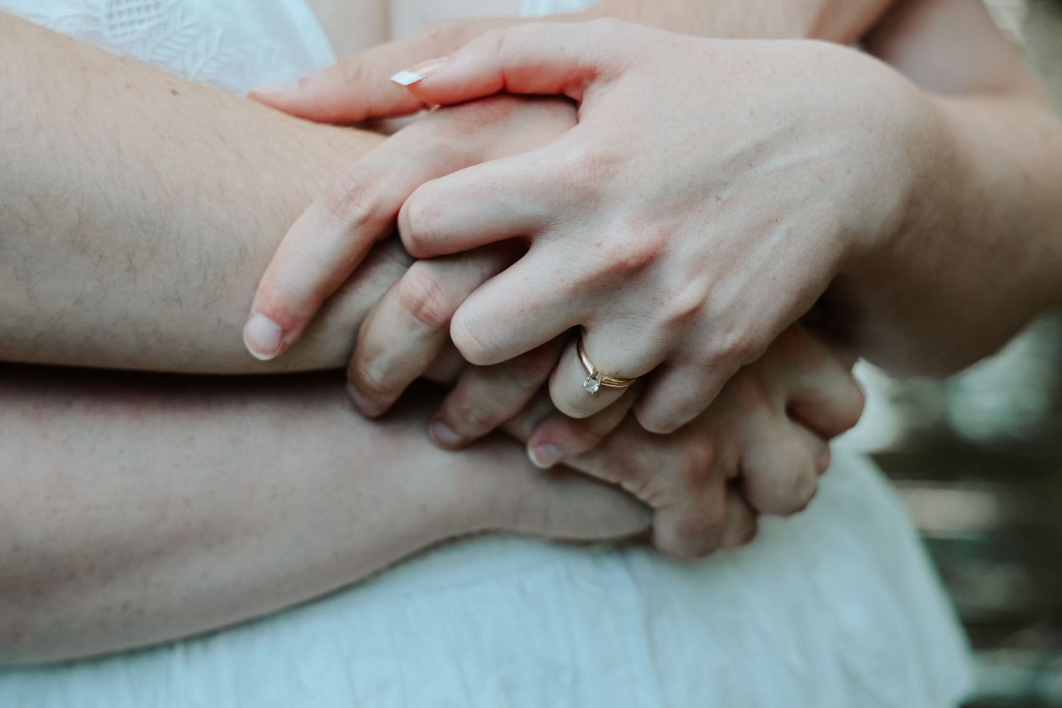 Close-up of two people holding hands with wedding rings, symbolizing love and commitment in marriage.