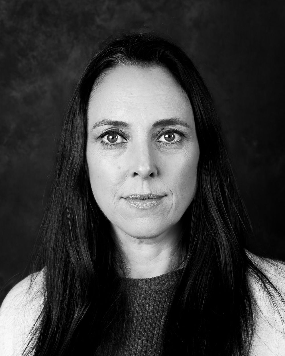 Dramatic black and white headshots showing various expressions against dark backdrop.
