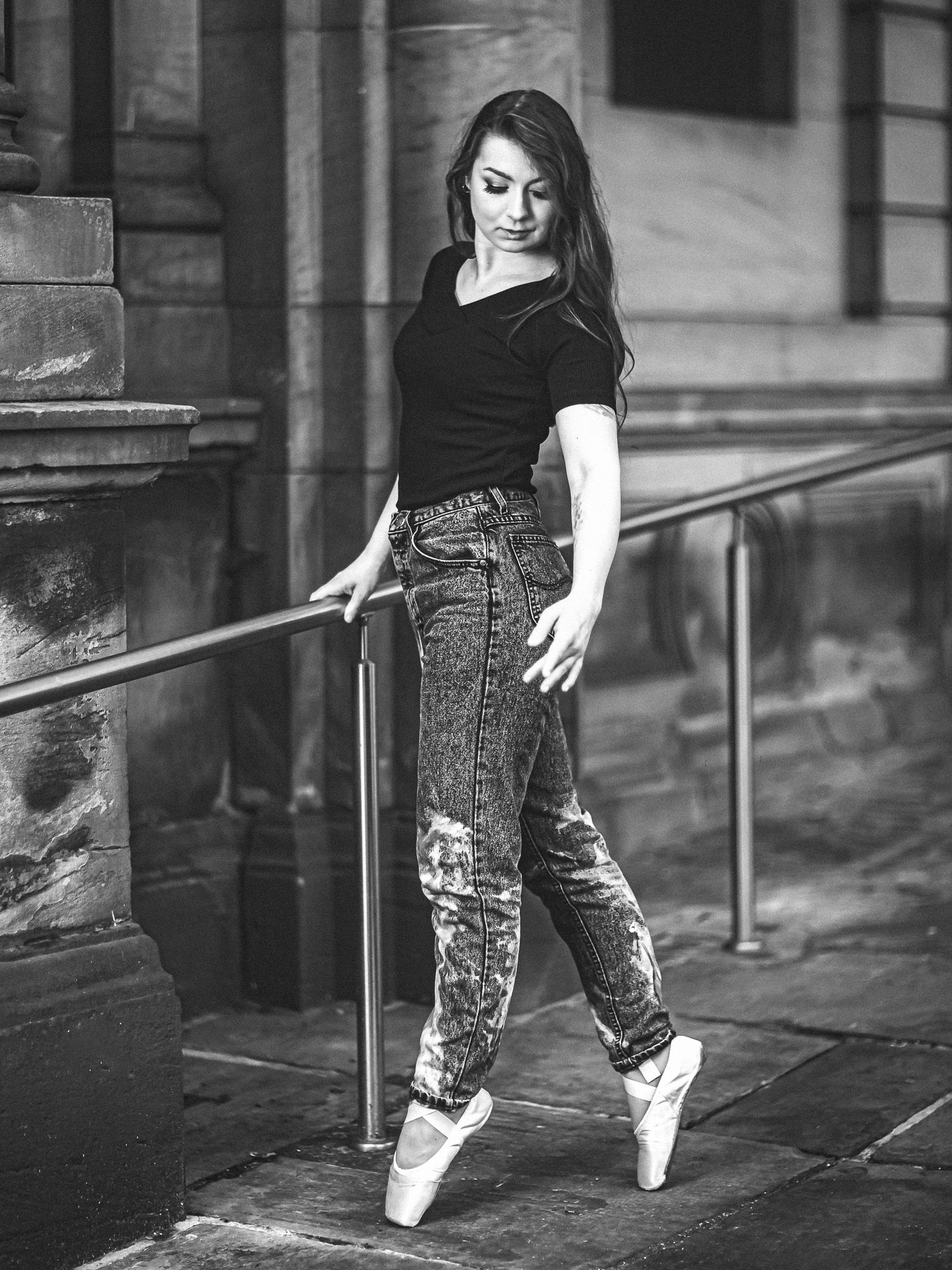 A dancer in patterned pants performs ballet moves in a series of black and white photos on a city street.
