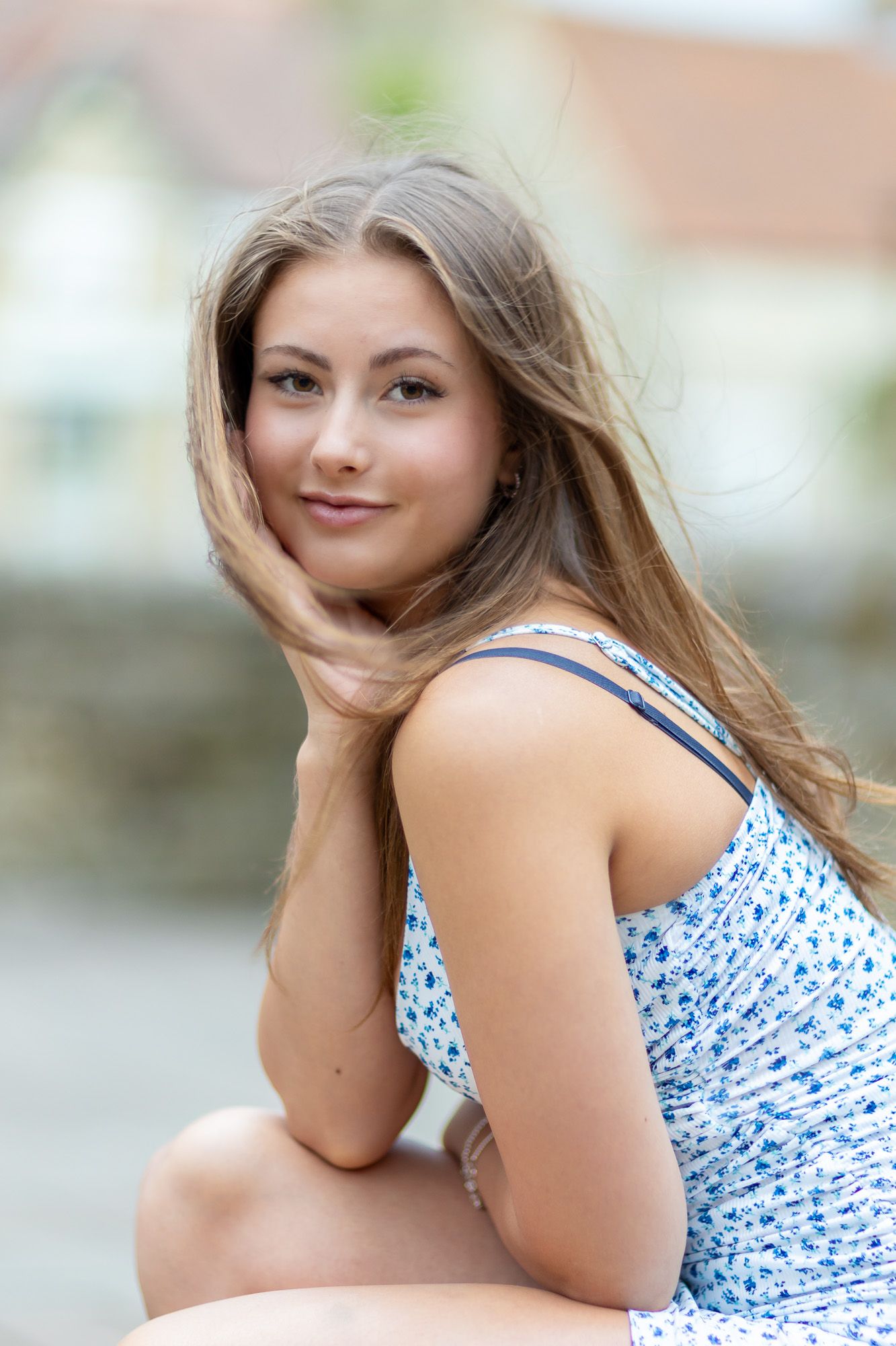 Fashion model in blue and white patterned dress poses outdoors in summer photoshoot series.