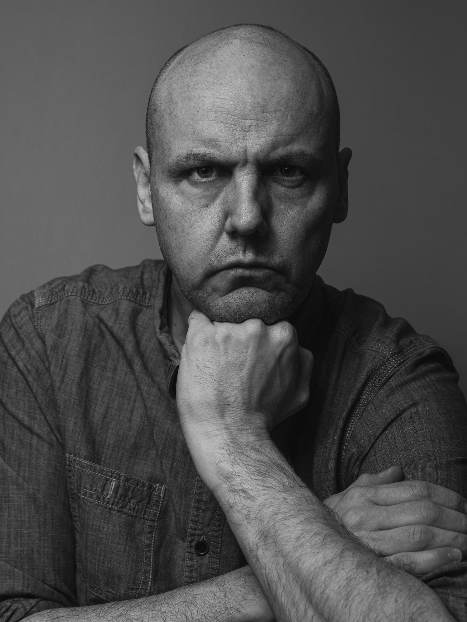 Black and white portrait series showing a contemplative figure in a button-down shirt resting hand against face in different poses.