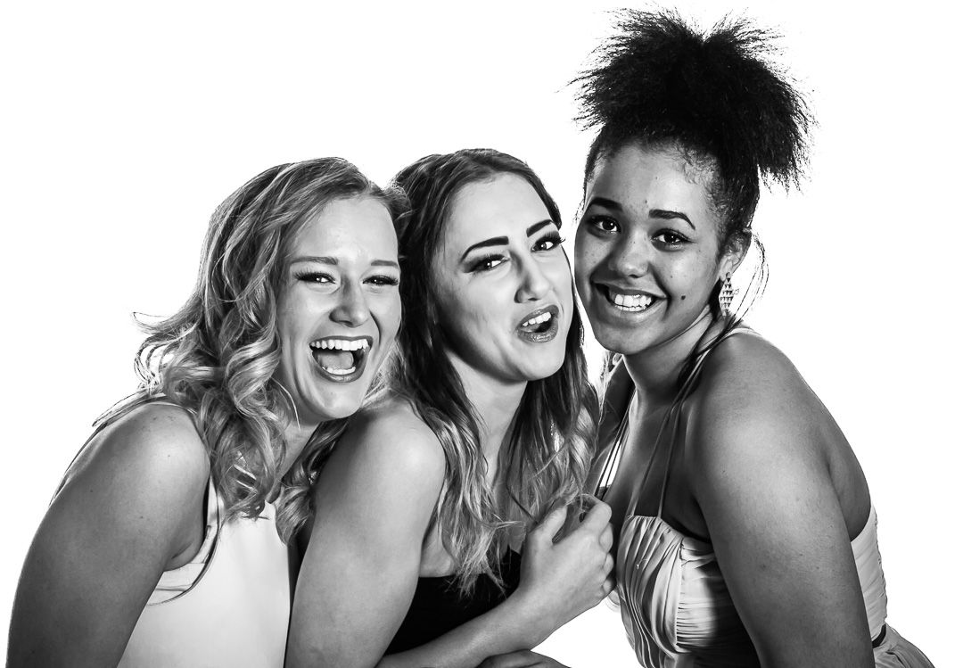 Black and white portrait series showing joyful group poses with natural expressions and laughter.