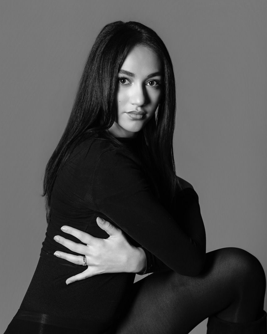 Artistic black and white portraits in dark clothing showing dramatic poses against grey background.