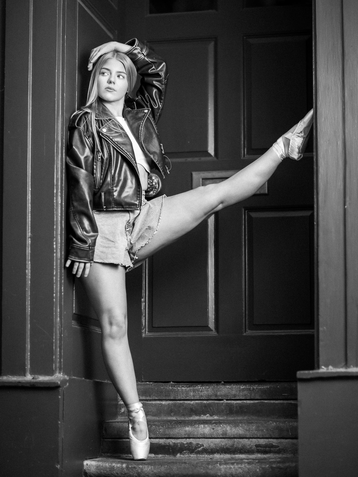 Ballet dancer strikes elegant poses in black and white series against dark doorway and steps.