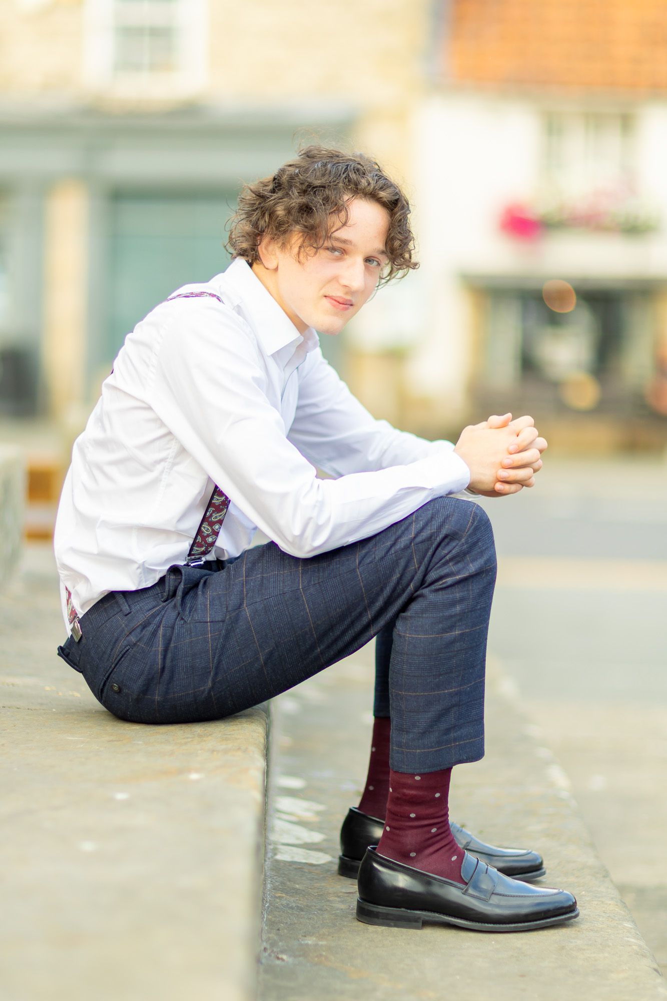 Close-up of burgundy socks and dress shoes with navy suit.
