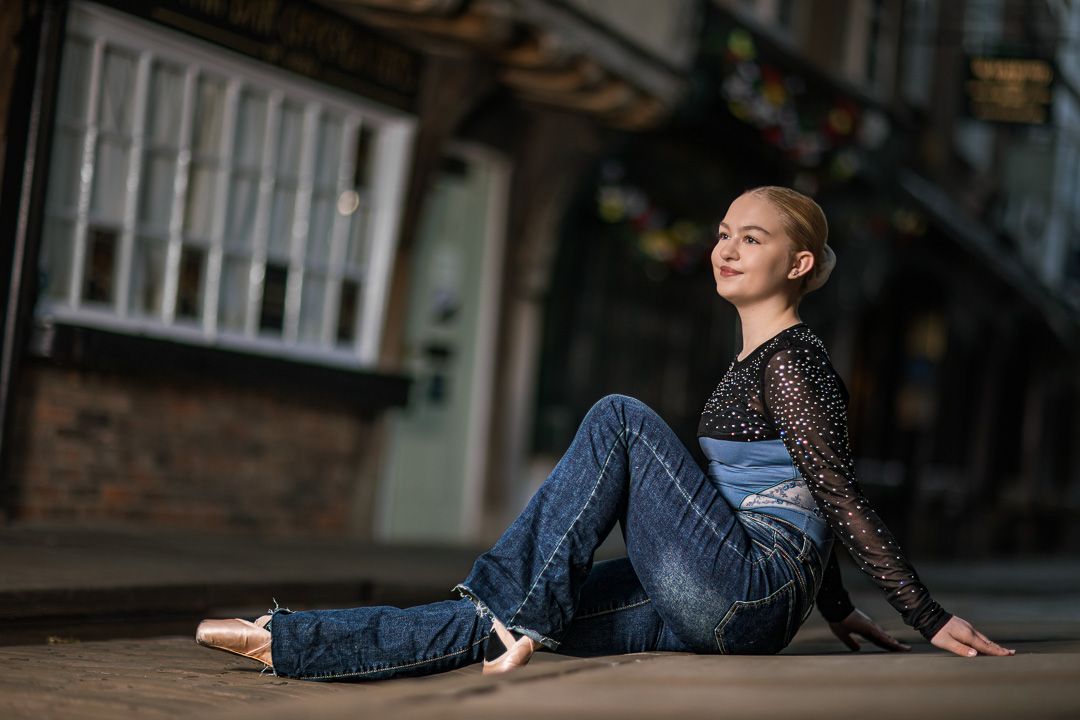 Dancer performs elegant movements on a historic cobblestone pathway.