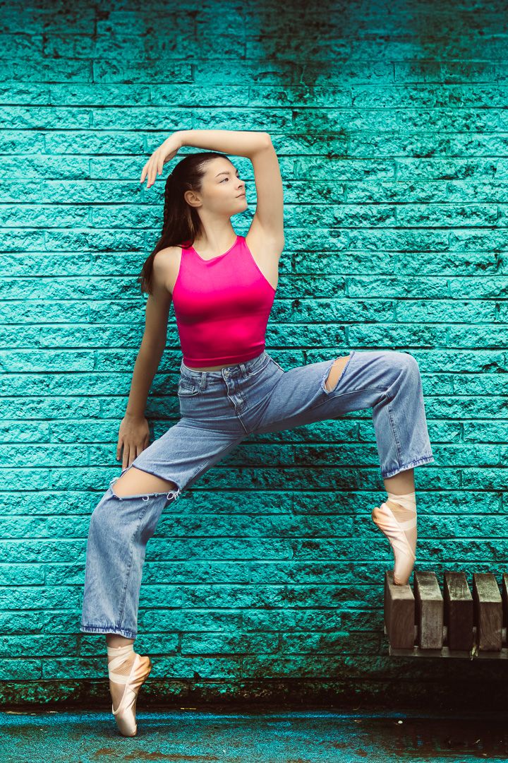 Dance sequence against turquoise brick wall showing dynamic movement in casual attire.
