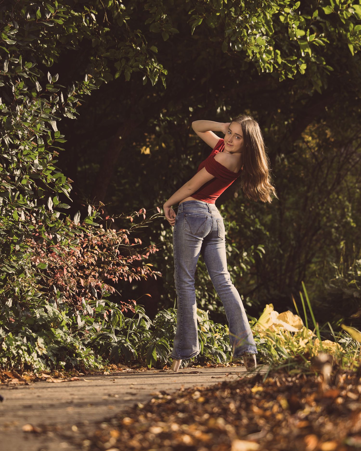 A sequence of dance movements captured in autumn sunlight showing graceful footwork on a leaf-covered path.