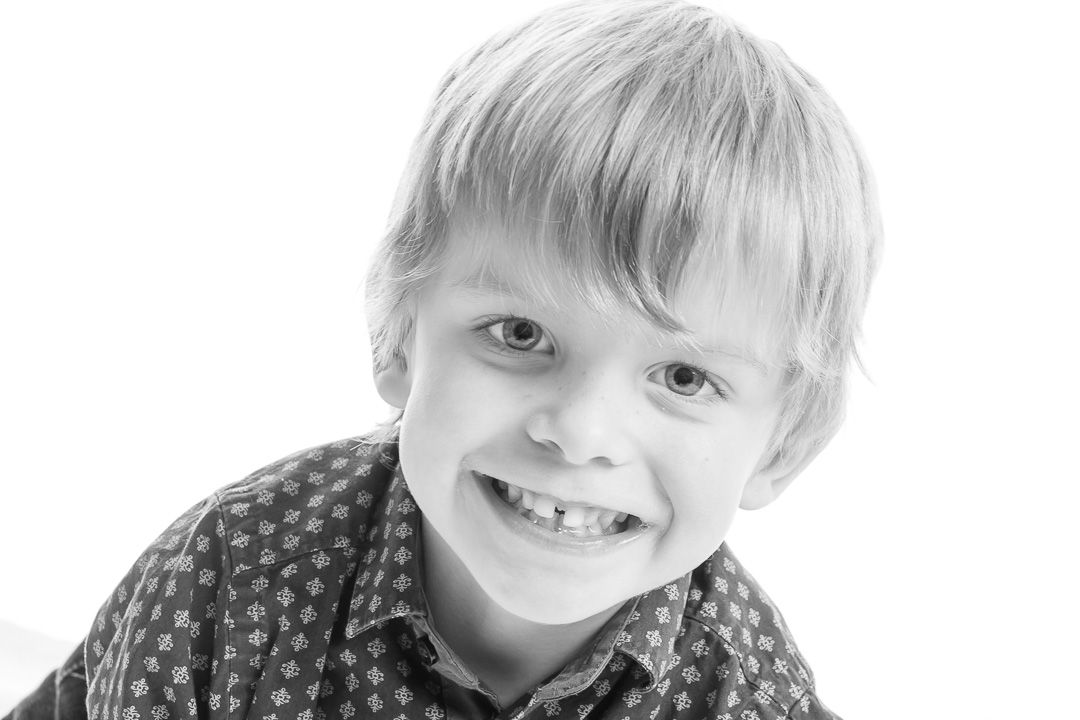 Black and white close-up portraits of a child showing different playful expressions.