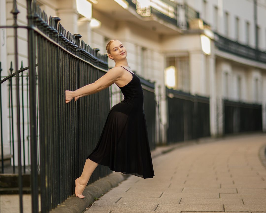Dancer performs elegant movements along a historic stone walkway.