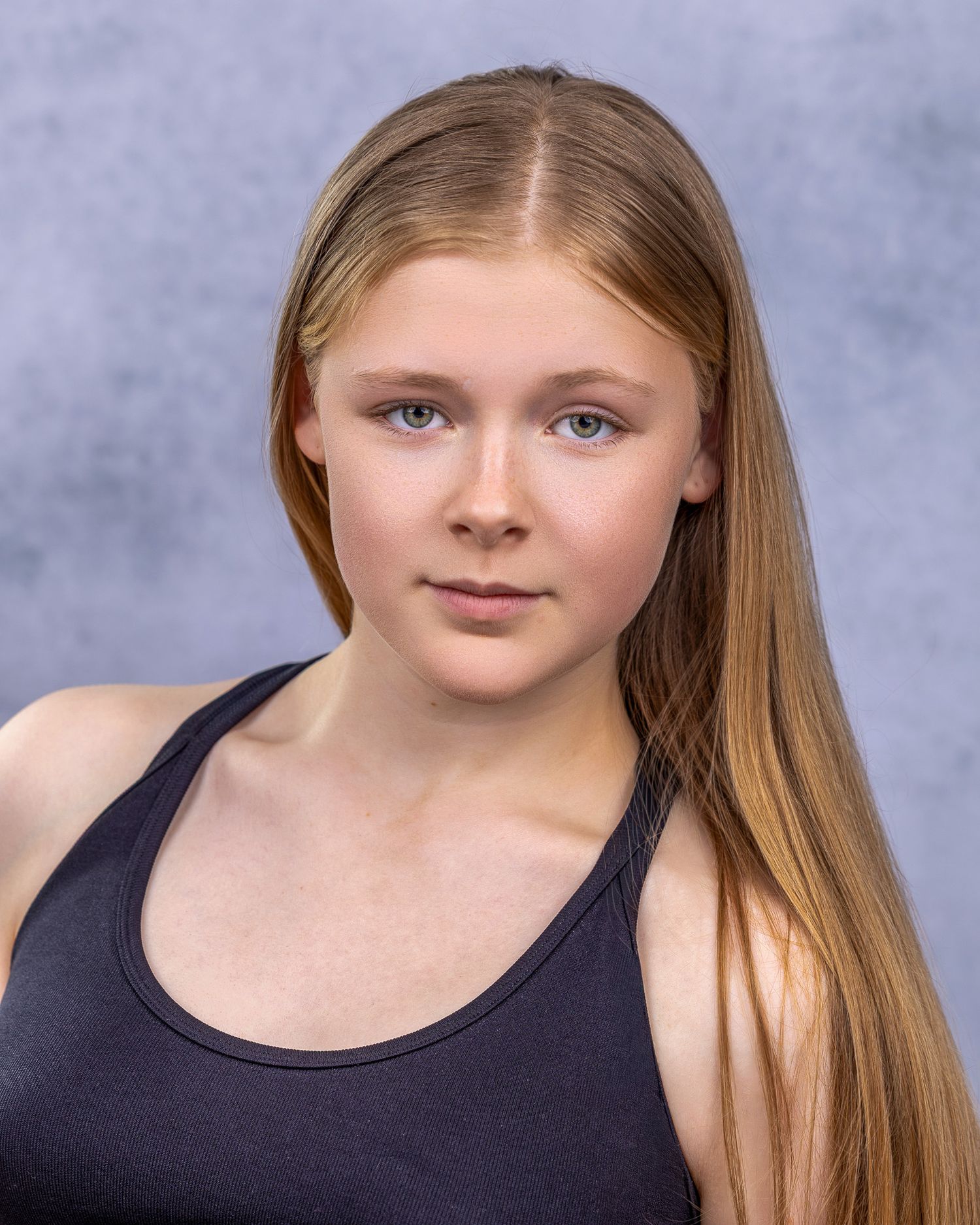 A series of four studio portraits showing a young person with long blonde hair against a mottled blue background.