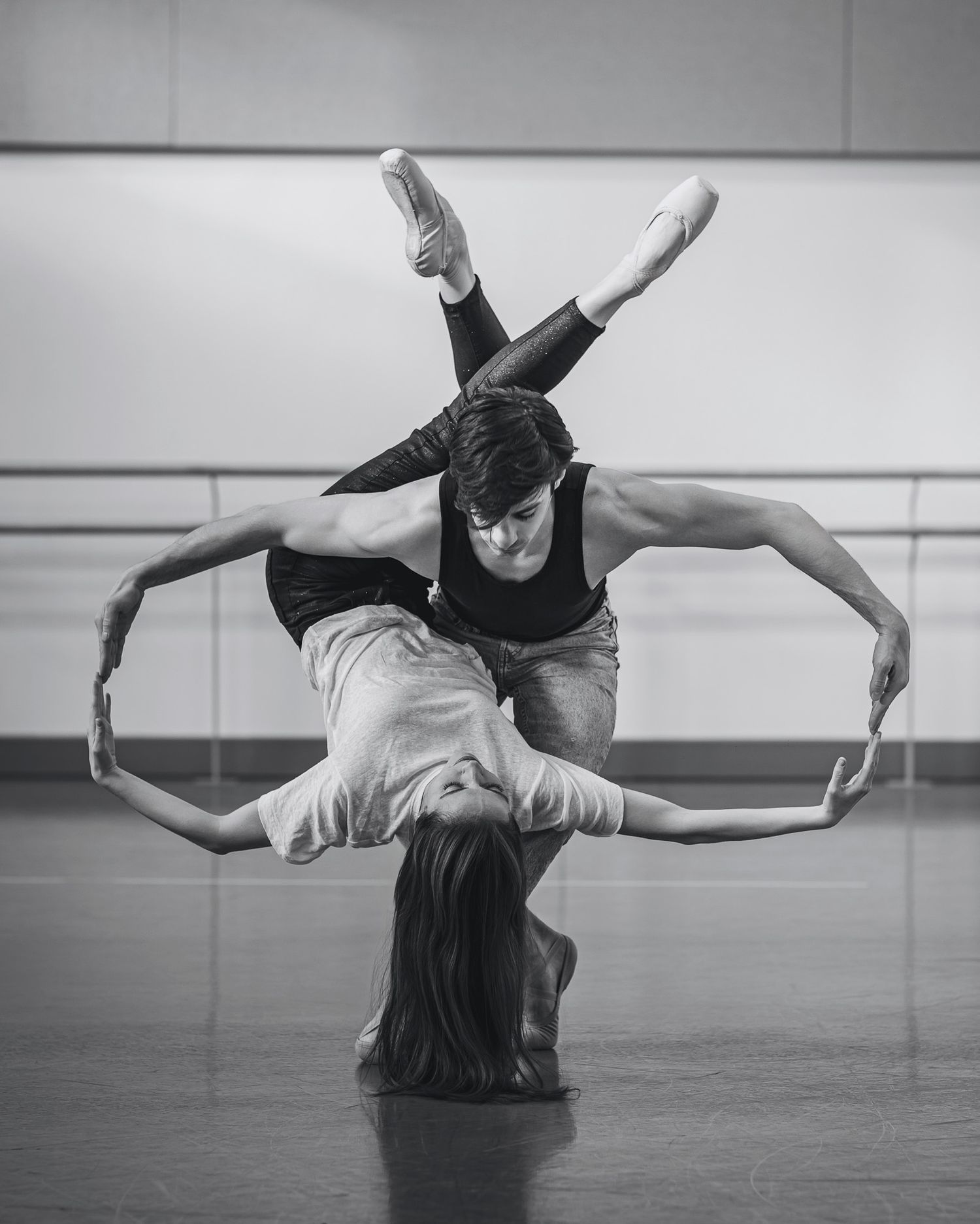 A series of black and white photographs showing modern dancers performing graceful movements and poses in a studio.