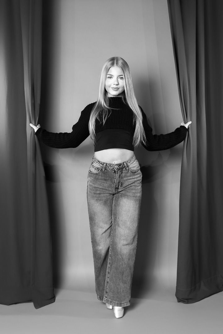 Dance photoshoot featuring casual denim style against grey curtain background.