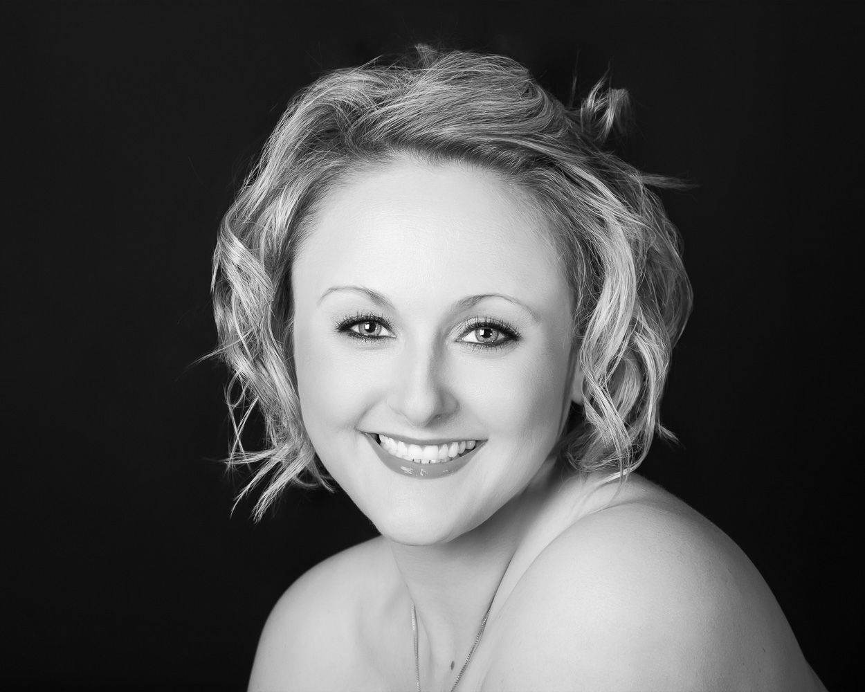 Black and white portrait series with dramatic lighting against dark background.