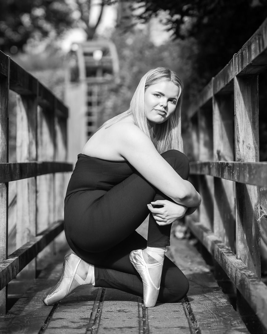 Black and white artistic dance portraits captured on wooden bridge.