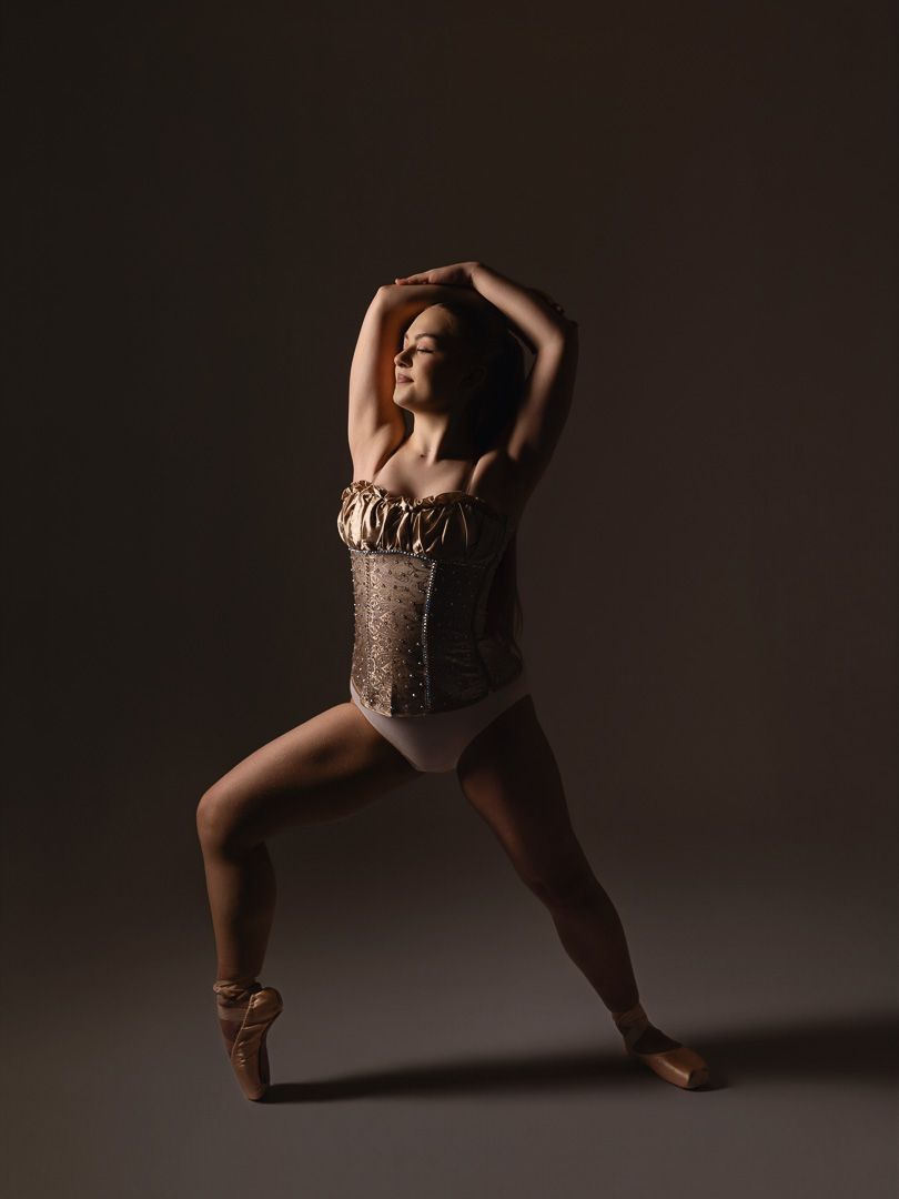 Dramatic studio portraits of a dancer in a sequined costume performing expressive movements in low-key lighting.