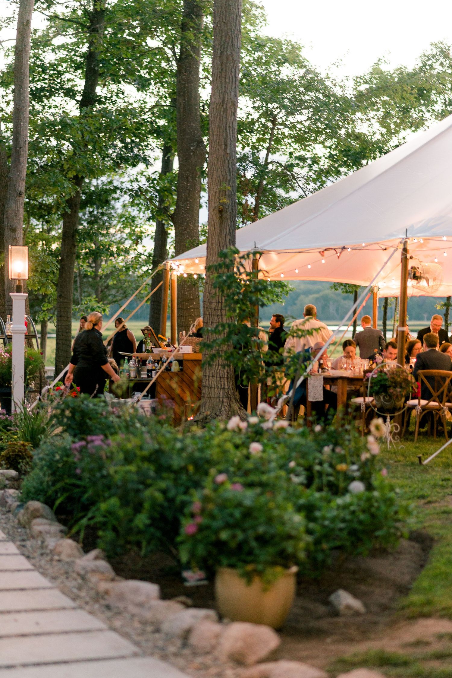 a detail shot of a white tent in the evening during a garden wedding