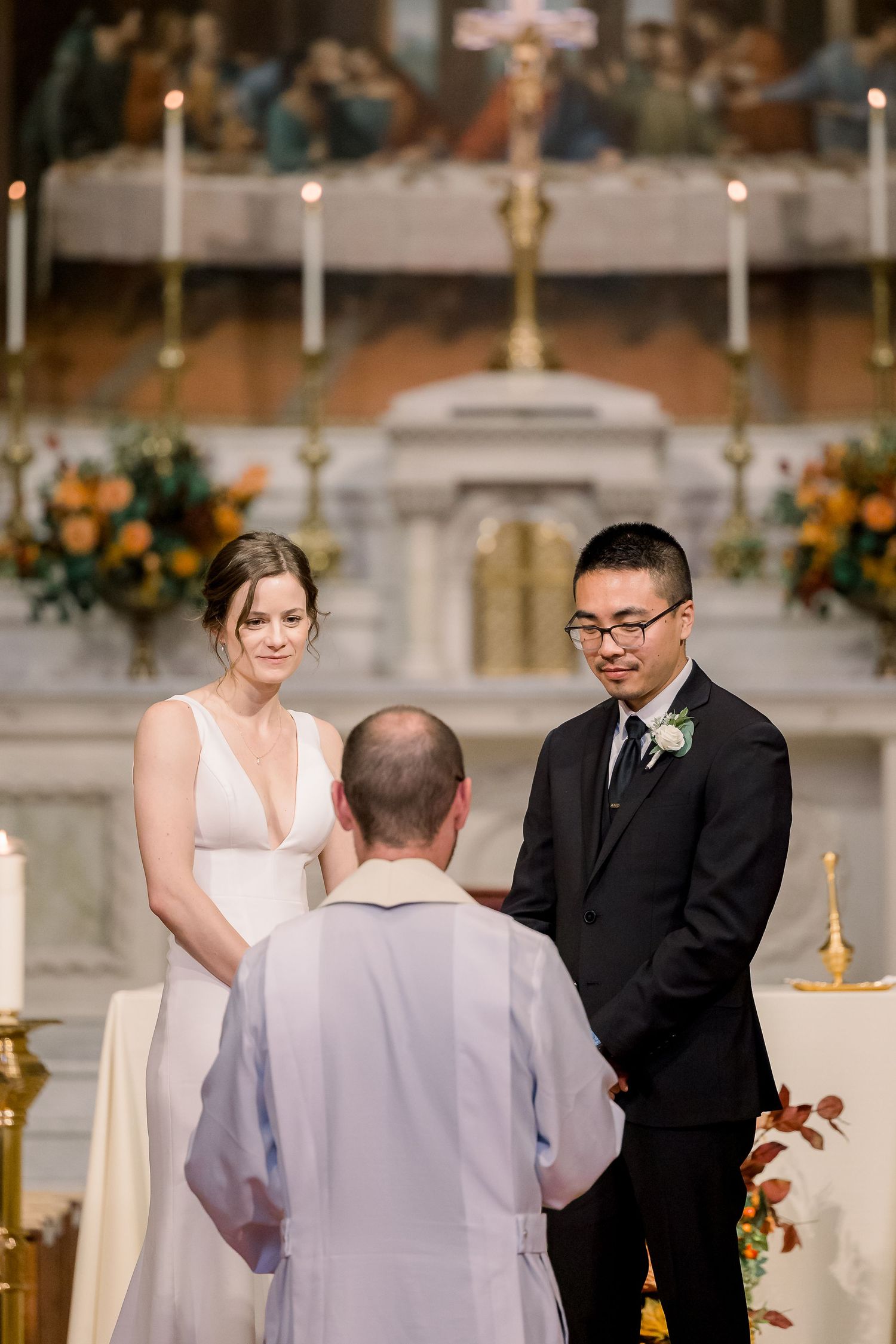 a bride and groom receive blessings from the priest during a church wedding ceremony