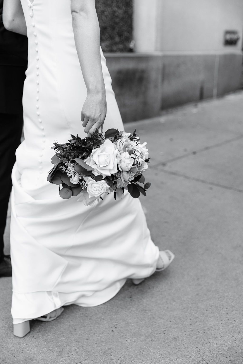 A candid black and white detail shot of a city bride's bouquet.