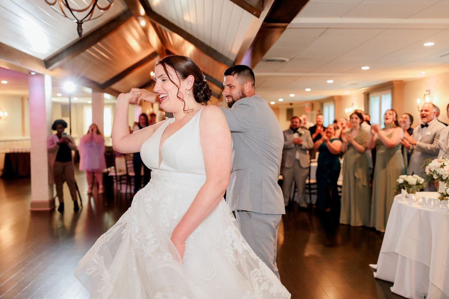 A bride and groom twirl in a dance at their wedding reception.