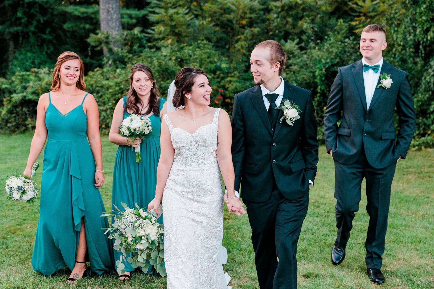 A bride and groom walk with their wedding party.