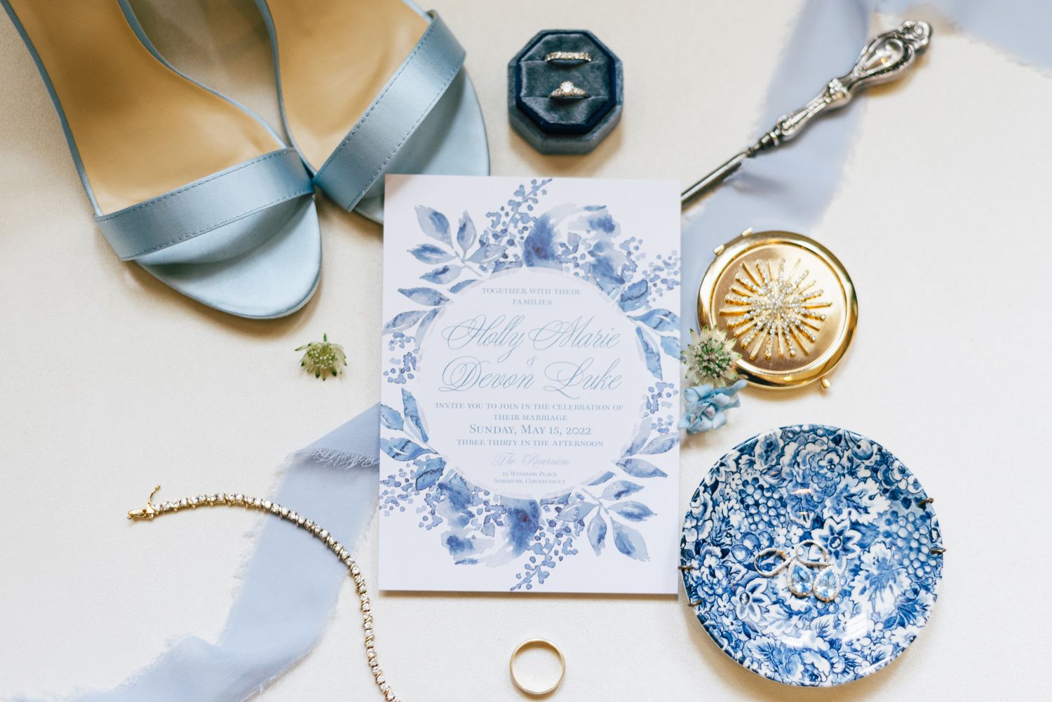 A flat lay of bridal of blue china and bridal details.