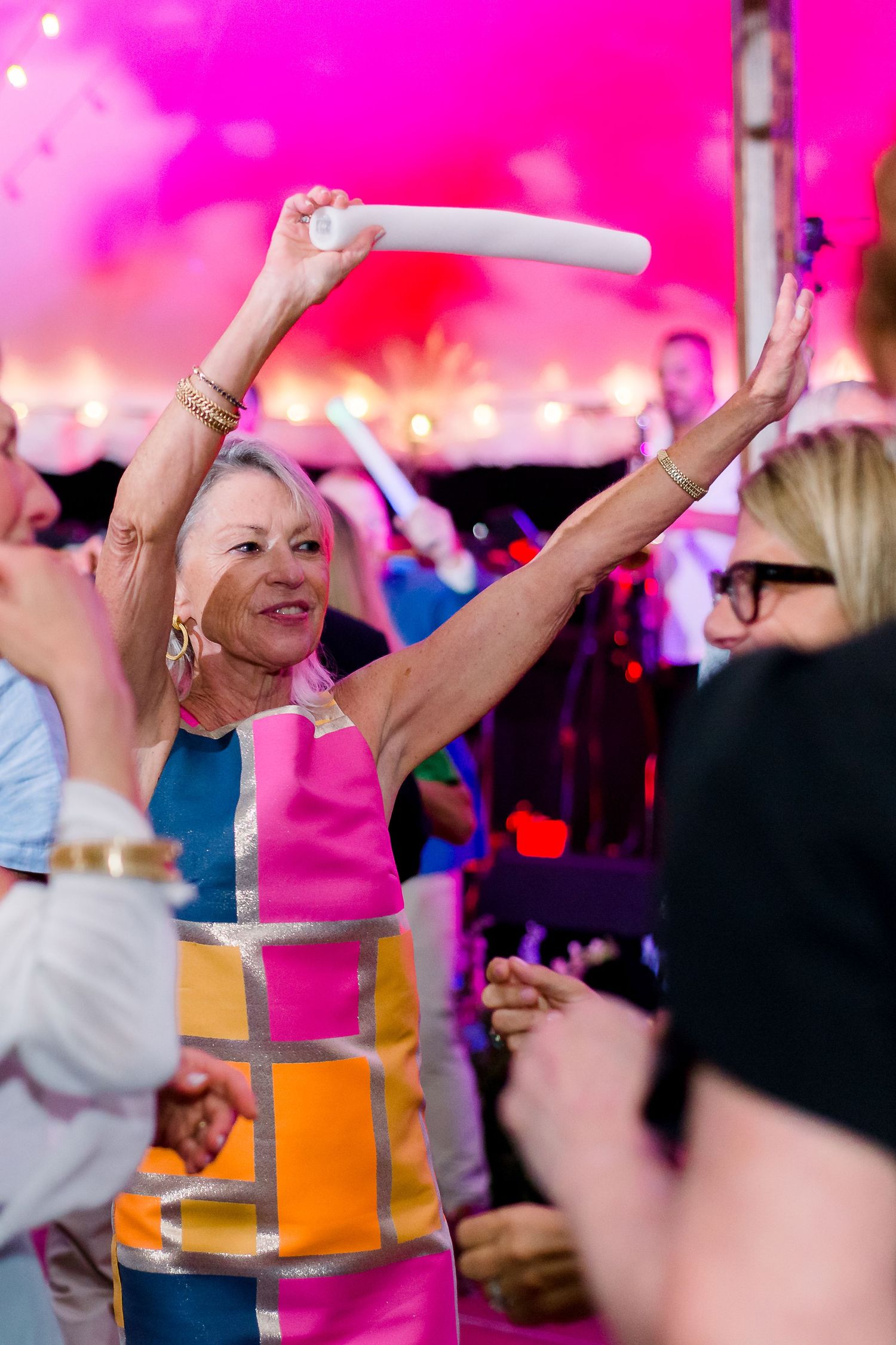 a colorfully dressed wedding guest dances at an afterparty