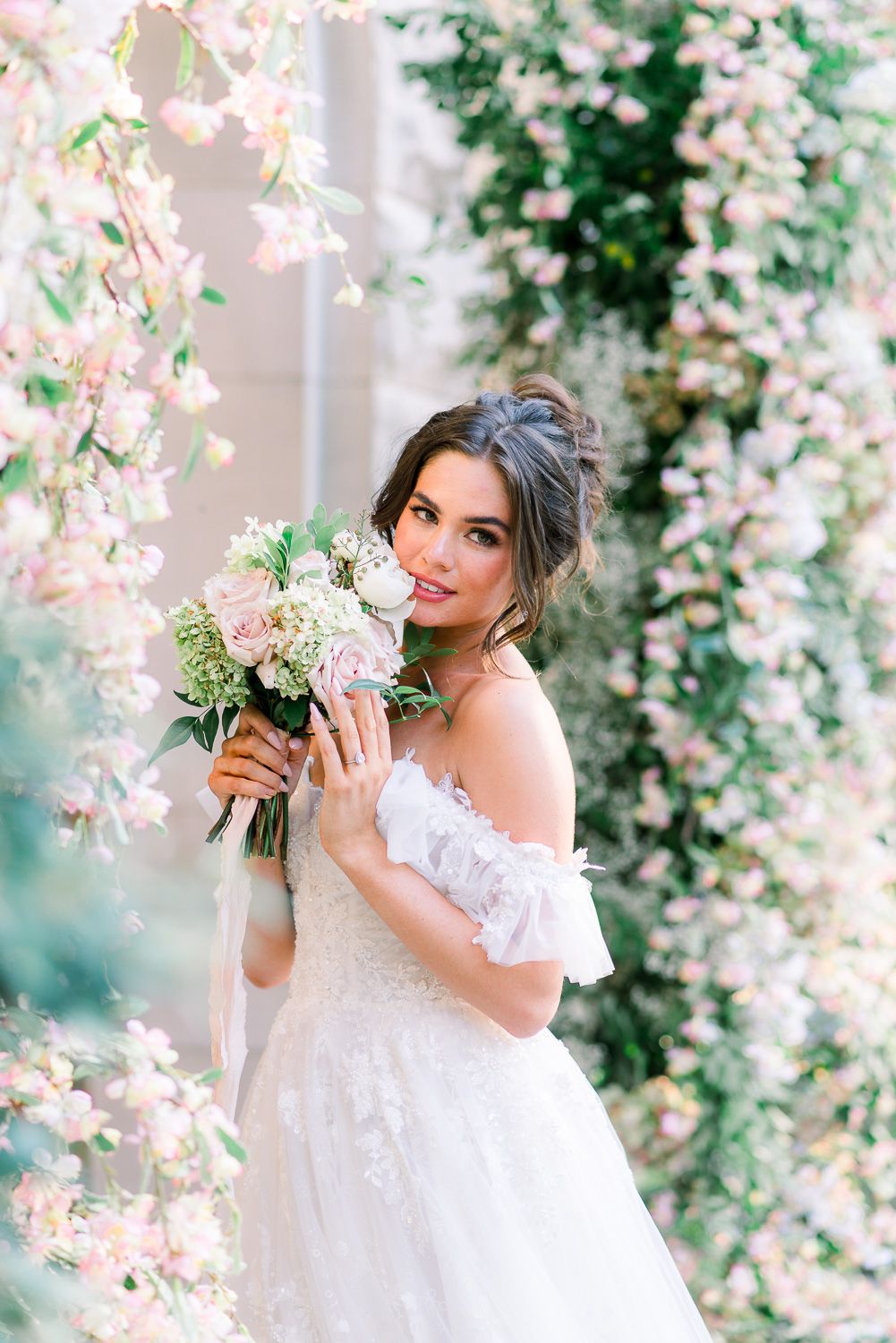 A bride surrounded by flowers at an historic castle wedding venue