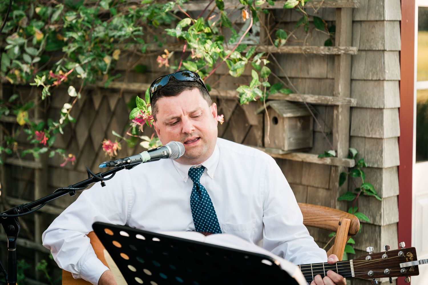 a man sings and plays the guitar at a cocktail hour