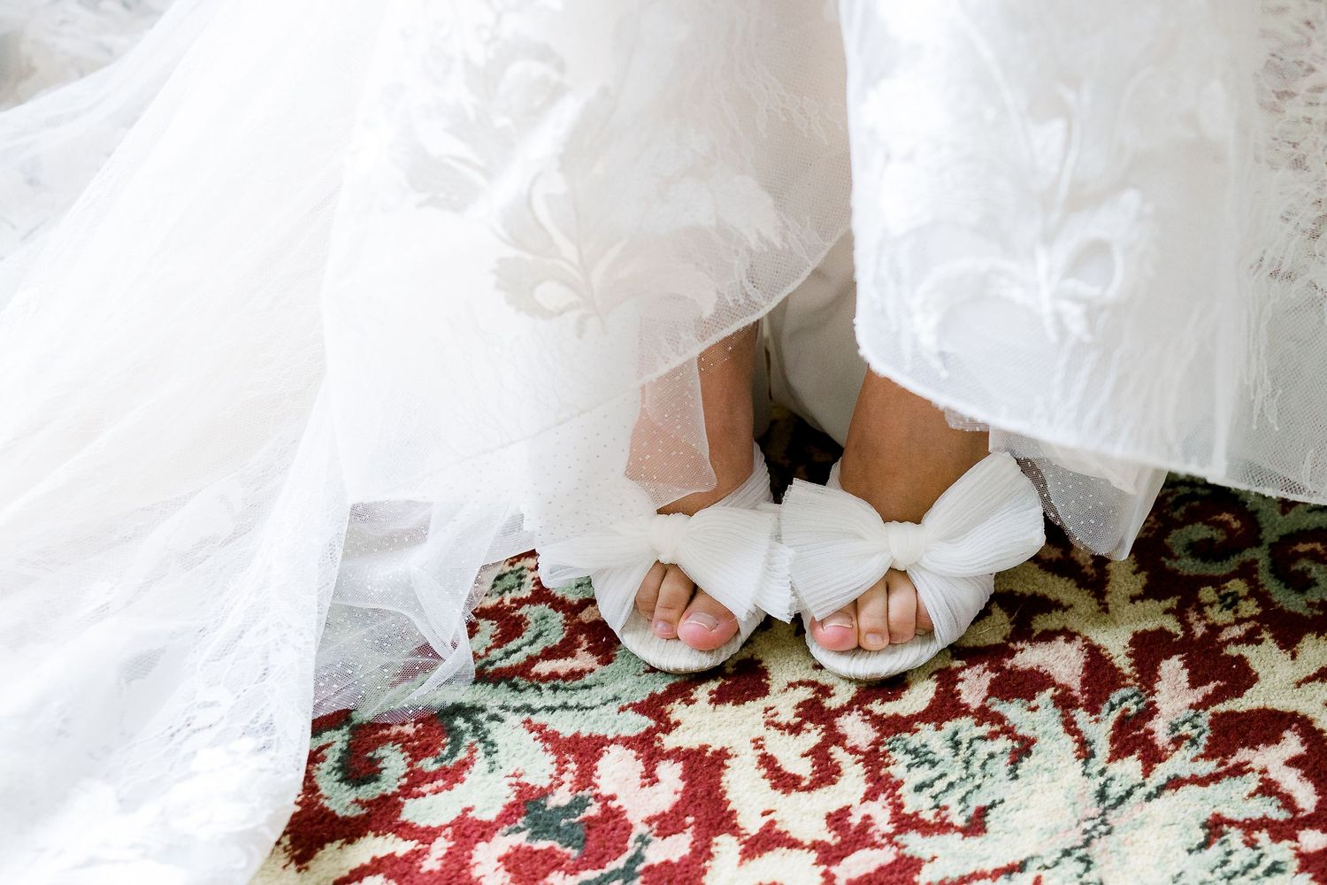 A detail shot of a bride's shoes against carpet.