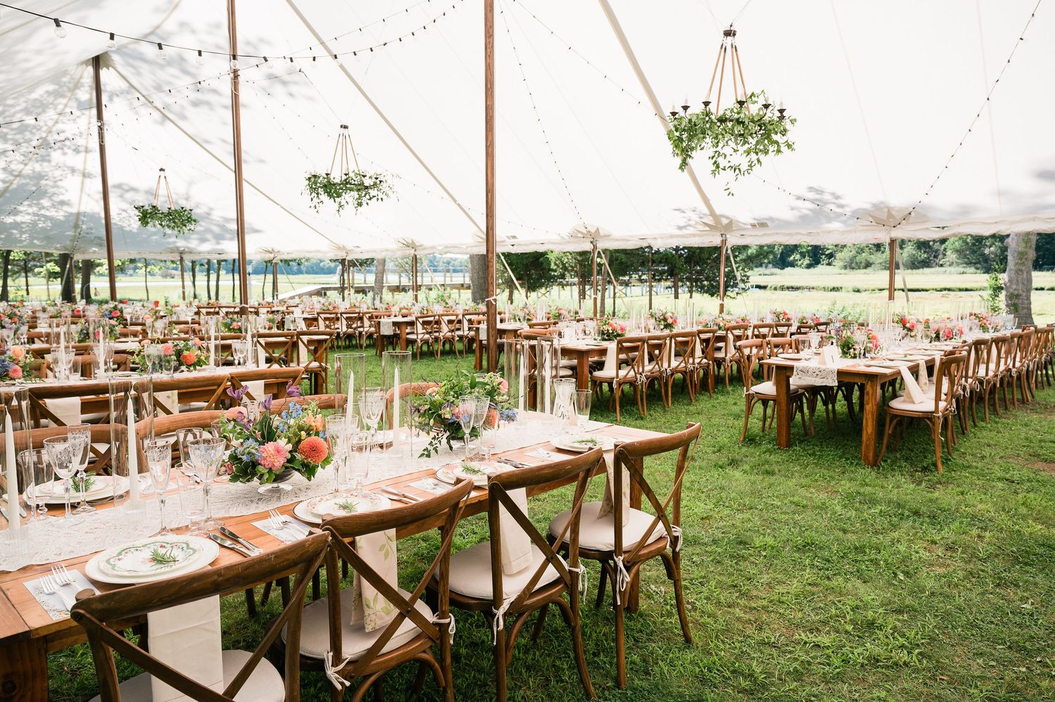 A detail shot of a white tent garden wedding reception.